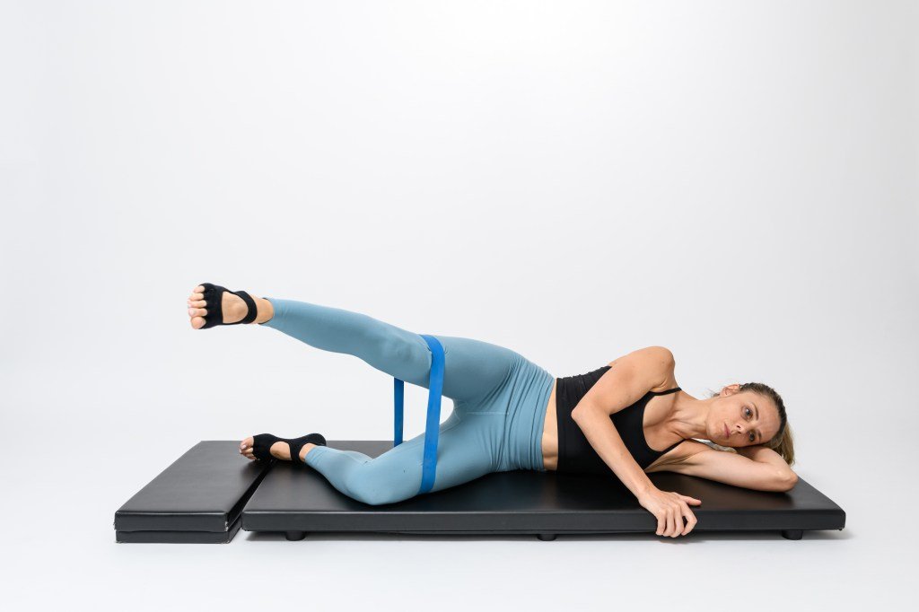 Laura Wilson demonstrates the exercise of lifting lateral legs with a resistance band.