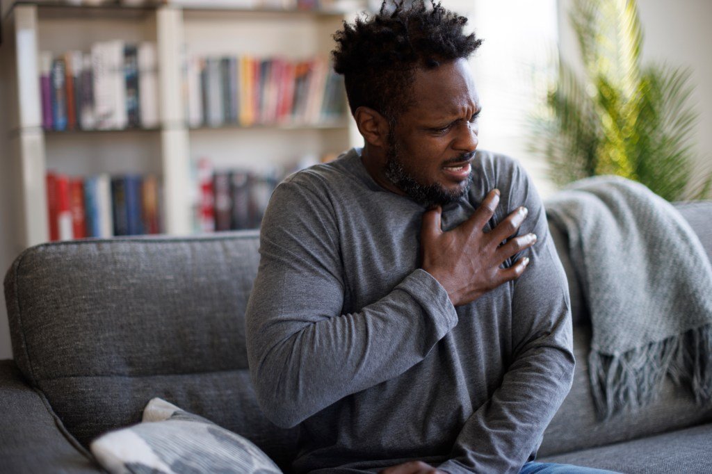 Man shakes his chest in pain