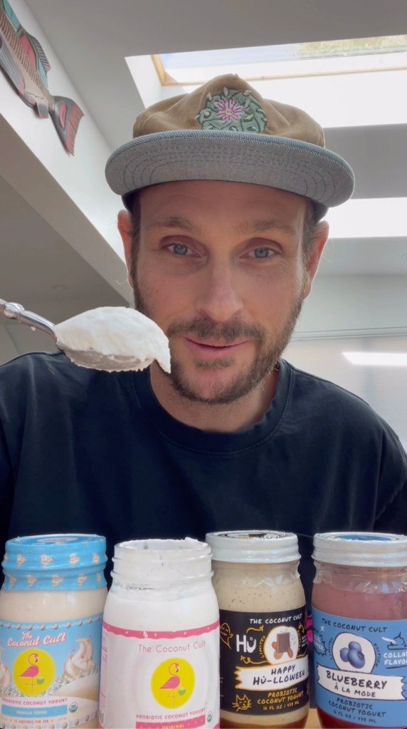 Noah Simon-Waddell, founder of Coconut Cult, holding a spoonful of yogurt, promoting health benefits in his Tiktok account.